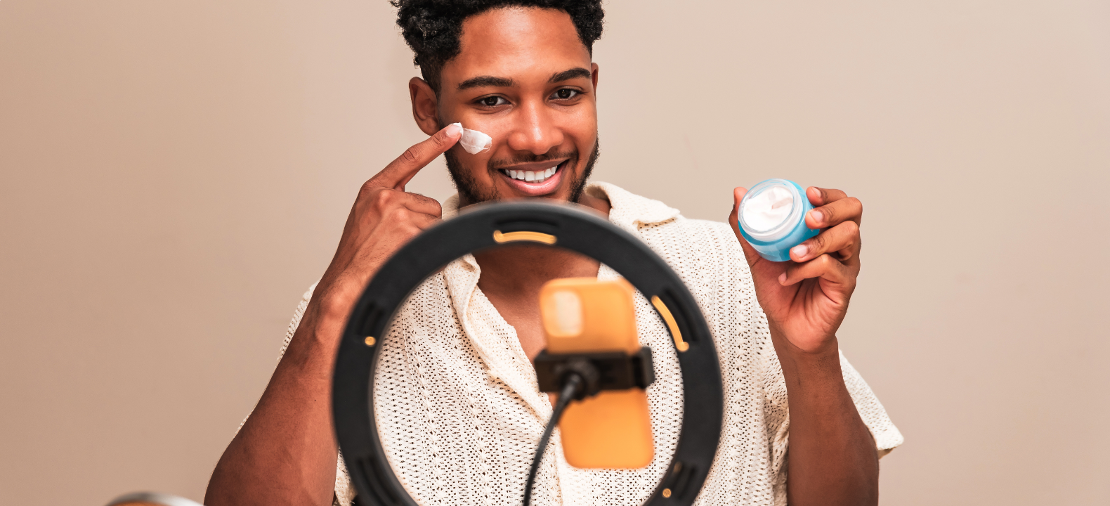 Ein Influencer, der in die Kamera blickt und eine Creme bewirbt.